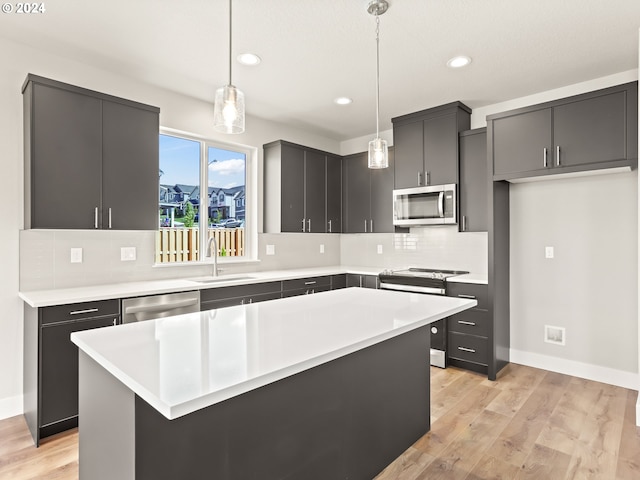 kitchen featuring pendant lighting, appliances with stainless steel finishes, sink, and a center island