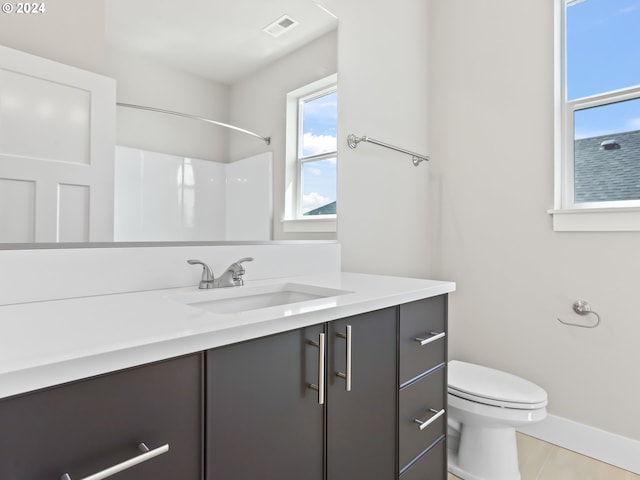 bathroom featuring a shower, tile patterned floors, vanity, and toilet