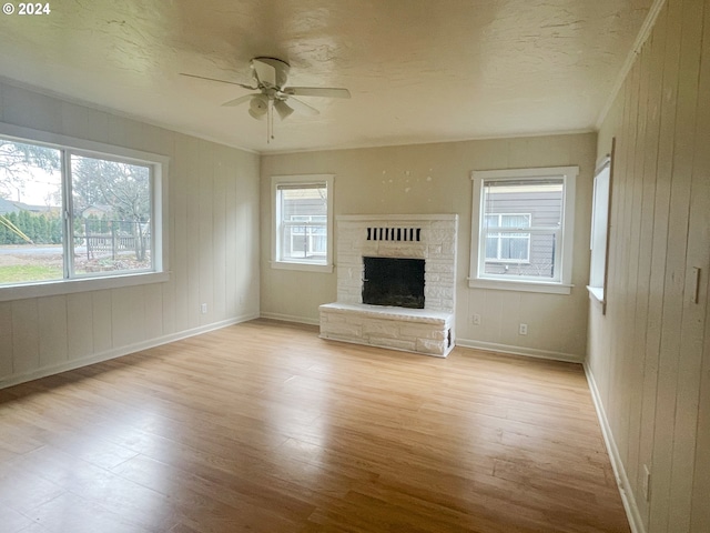 unfurnished living room featuring ceiling fan, a healthy amount of sunlight, and light hardwood / wood-style floors