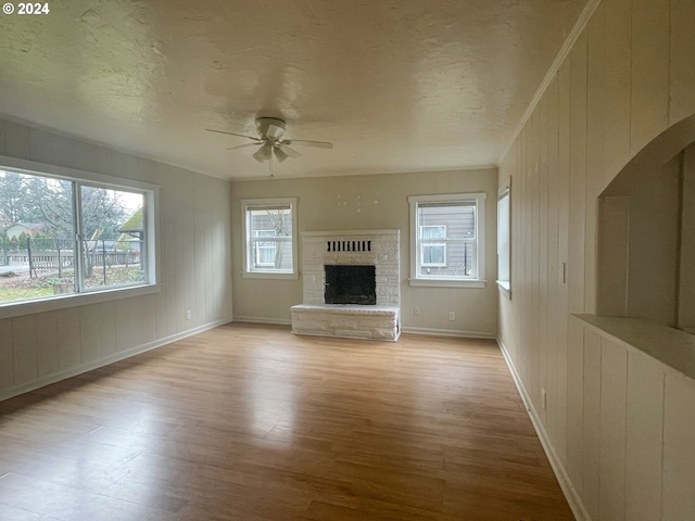 unfurnished living room featuring radiator heating unit, light hardwood / wood-style floors, a wealth of natural light, and ceiling fan