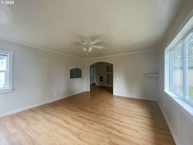 empty room with a wealth of natural light, ceiling fan, and light wood-type flooring