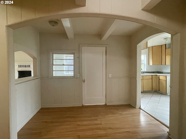 interior space with beamed ceiling and light hardwood / wood-style flooring