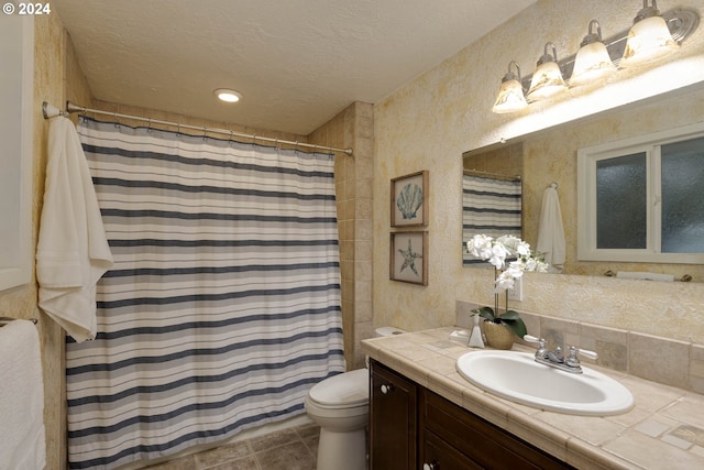 bathroom featuring vanity, tile patterned flooring, a shower with shower curtain, toilet, and a textured ceiling