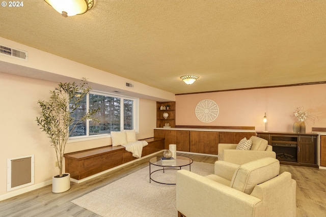 living room featuring light wood-type flooring and a textured ceiling