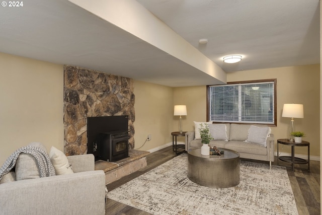 living room featuring a wood stove and dark wood-type flooring