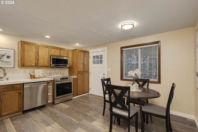 kitchen featuring decorative backsplash, stainless steel appliances, dark hardwood / wood-style floors, and sink