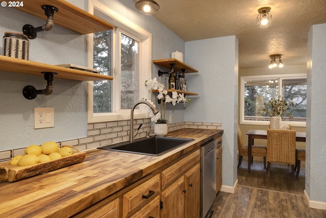 kitchen with butcher block counters, dishwasher, sink, dark hardwood / wood-style floors, and backsplash