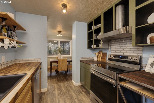 kitchen with backsplash, wall chimney exhaust hood, butcher block counters, and stainless steel appliances