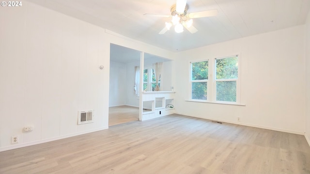 unfurnished room with light wood finished floors, a ceiling fan, and baseboards