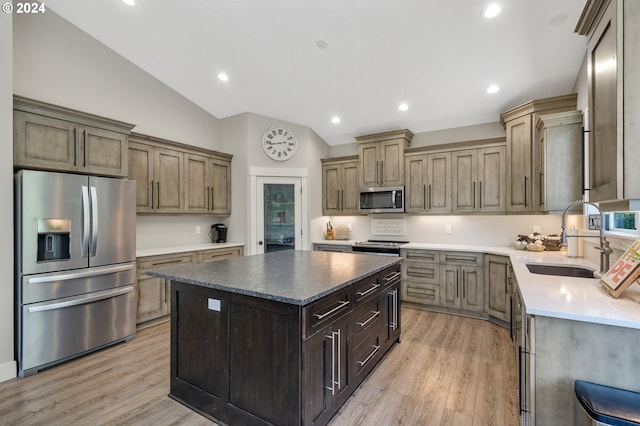 kitchen featuring vaulted ceiling, sink, a center island, light hardwood / wood-style floors, and stainless steel appliances