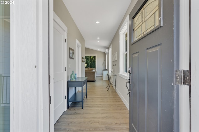 corridor featuring vaulted ceiling and light hardwood / wood-style floors