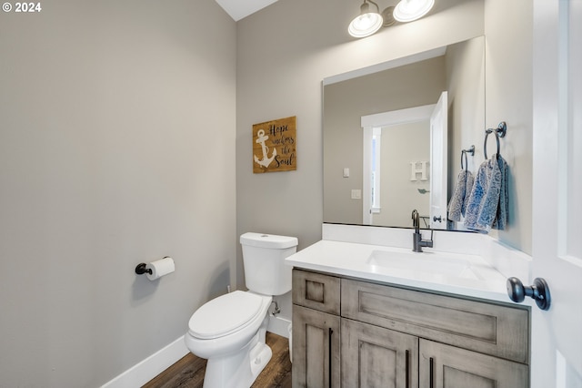 bathroom with hardwood / wood-style flooring, vanity, and toilet