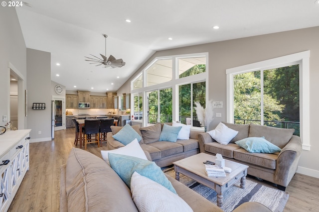 living room featuring high vaulted ceiling and light wood-type flooring