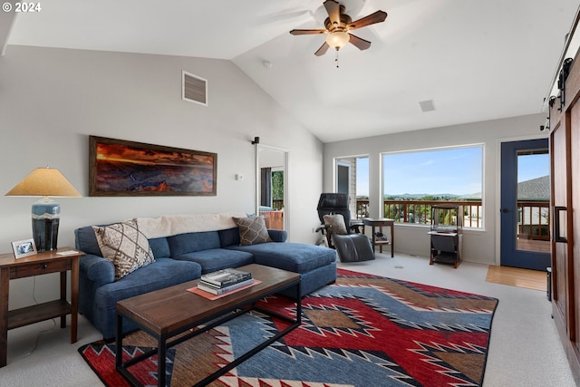 living room with high vaulted ceiling, a barn door, carpet flooring, visible vents, and a ceiling fan