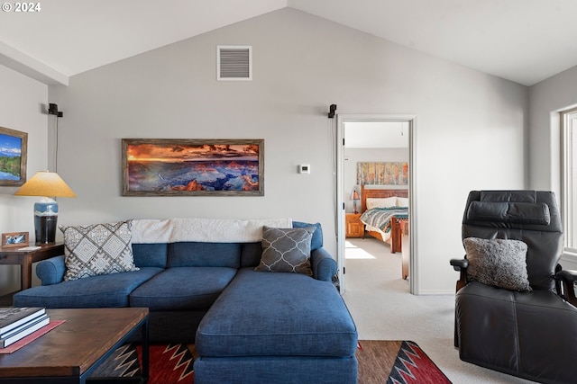 living room featuring lofted ceiling, carpet floors, and visible vents