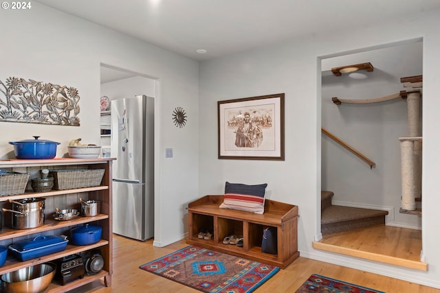 interior space with light wood finished floors, stairs, and baseboards