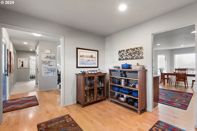 corridor featuring light wood-type flooring, baseboards, and recessed lighting