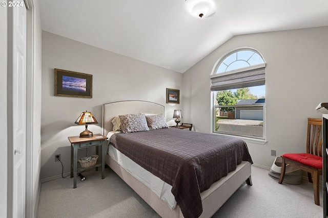 bedroom with light carpet, vaulted ceiling, and baseboards