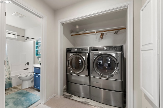 washroom with laundry area, visible vents, and independent washer and dryer