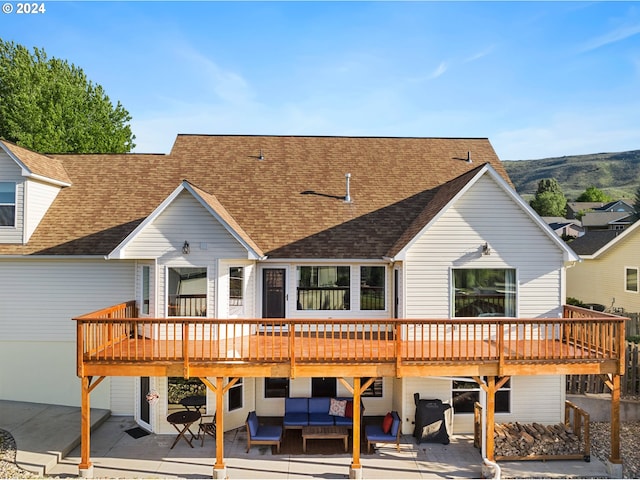 back of property with a patio, roof with shingles, outdoor lounge area, and a wooden deck