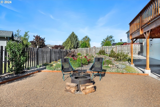 view of patio with an outdoor fire pit, a fenced backyard, and a wooden deck