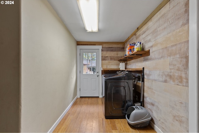 laundry room with light hardwood / wood-style floors, tile walls, and washing machine and clothes dryer