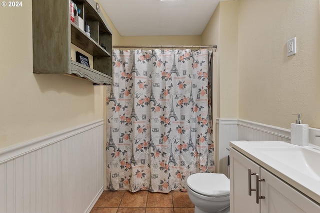 bathroom with tile patterned floors, vanity, toilet, and walk in shower