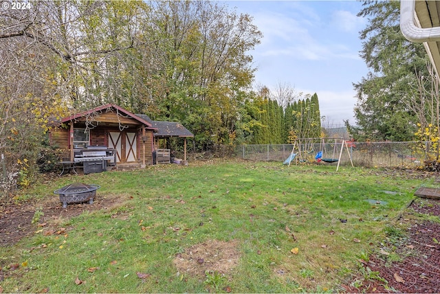 view of yard featuring a fire pit, a shed, and a playground