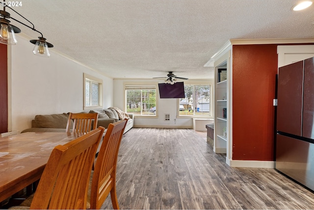 dining space featuring ceiling fan, hardwood / wood-style floors, and a textured ceiling