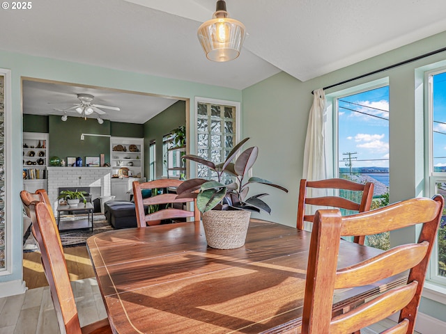 740 Florence Ave, Astoria, OR 97103 - dining space with a fireplace, wood finished floors, and ceiling fan