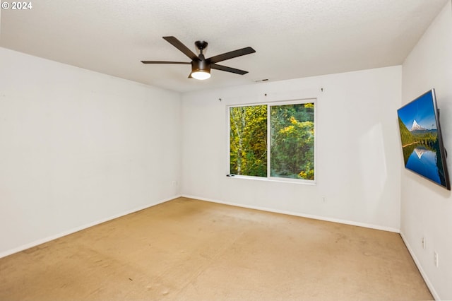 spare room featuring a textured ceiling, carpet, and ceiling fan