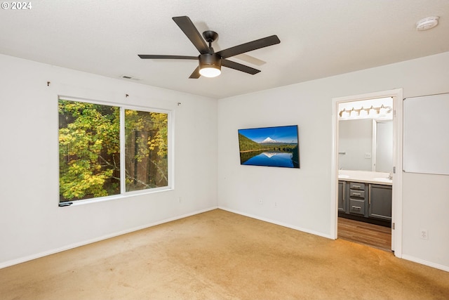 carpeted empty room with sink and ceiling fan