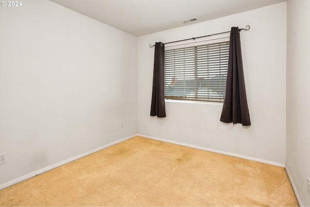 unfurnished room featuring light carpet