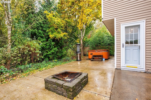 view of patio with a hot tub and an outdoor fire pit