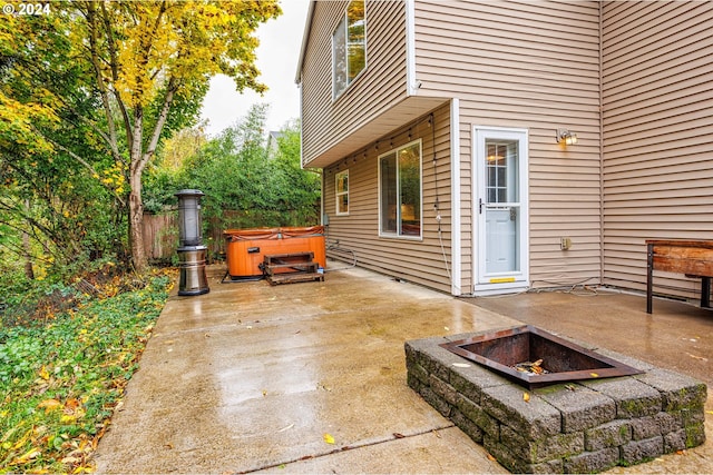 view of patio / terrace with a hot tub and a fire pit