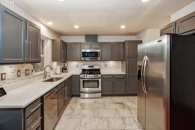 1018 NE Mariners Loop, Portland, OR 97211 - kitchen with appliances with stainless steel finishes, a sink, light marble finish floors, tasteful backsplash, and a textured ceiling