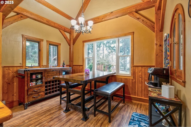 dining space featuring wood walls, hardwood / wood-style flooring, and a notable chandelier