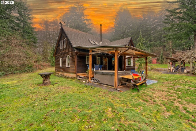 exterior space with a lawn and a hot tub