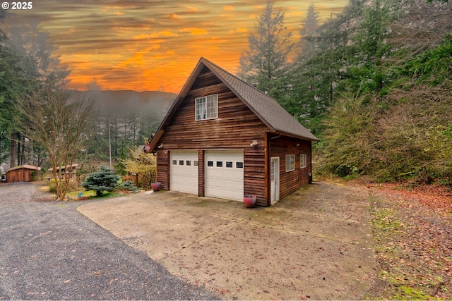 view of garage at dusk