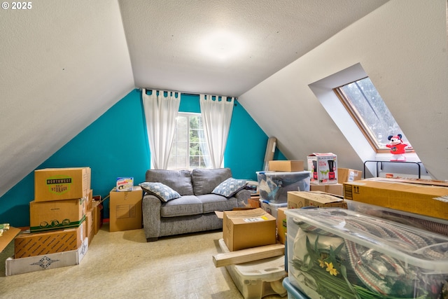 bonus room with a textured ceiling, light colored carpet, and vaulted ceiling with skylight