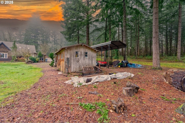 yard at dusk featuring an outbuilding