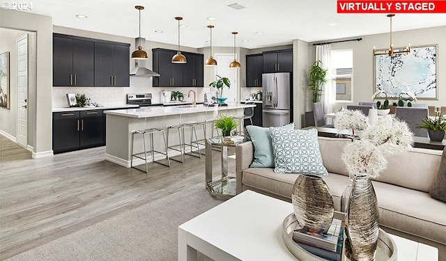 living room featuring light hardwood / wood-style flooring, a chandelier, and sink