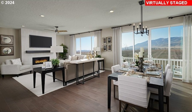 dining space featuring dark hardwood / wood-style flooring, a mountain view, a fireplace, and plenty of natural light