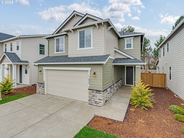 craftsman-style house featuring fence, a shingled roof, concrete driveway, a garage, and stone siding