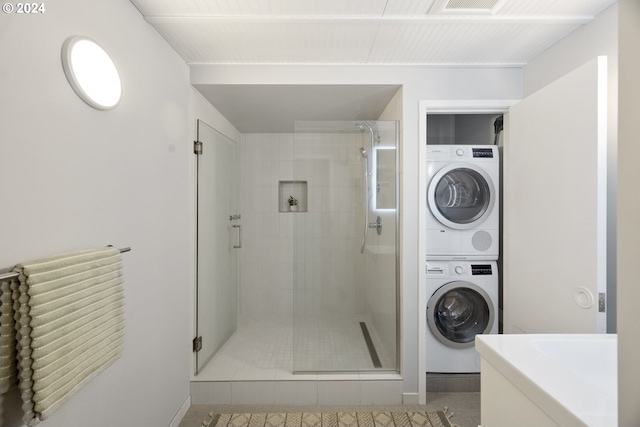 bathroom featuring a shower stall and stacked washing maching and dryer