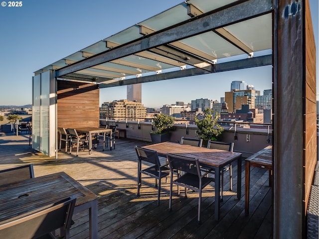 wooden deck with a city view and outdoor dining space