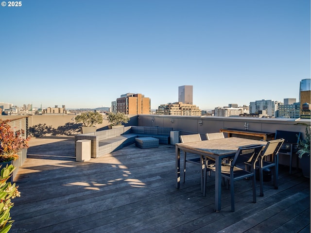 wooden deck with a city view and outdoor dining area