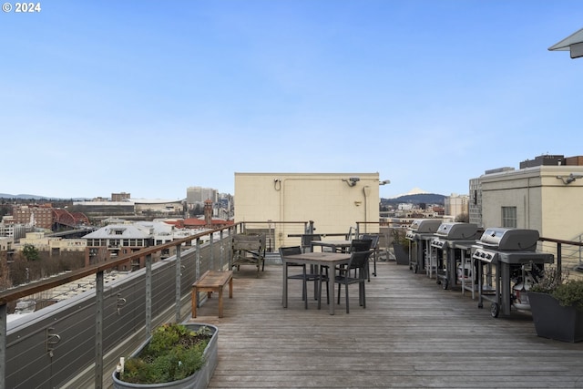 wooden deck with a grill and a view of city