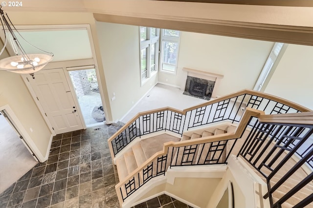 foyer entrance with a premium fireplace and a chandelier