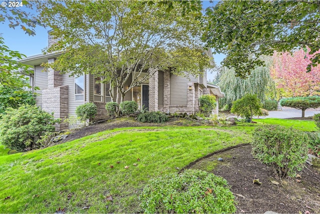 view of property hidden behind natural elements featuring a front yard